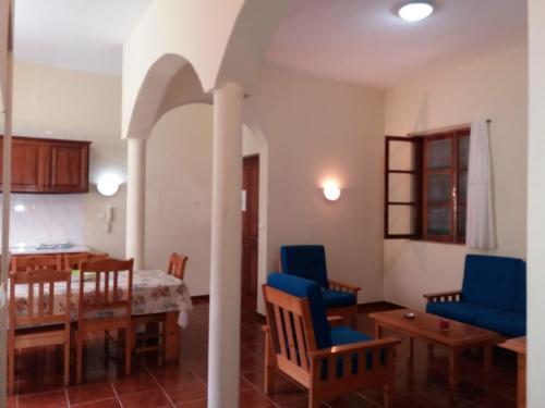 a kitchen and dining room with blue chairs and a table at Ribeira Grande Country House in Escabeçada