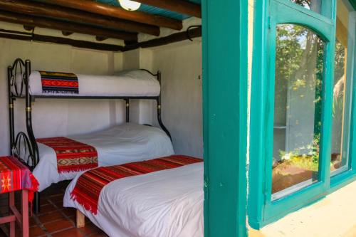 two bunk beds in a room with a window at Hostería Colibri Aeropuerto in Tababela