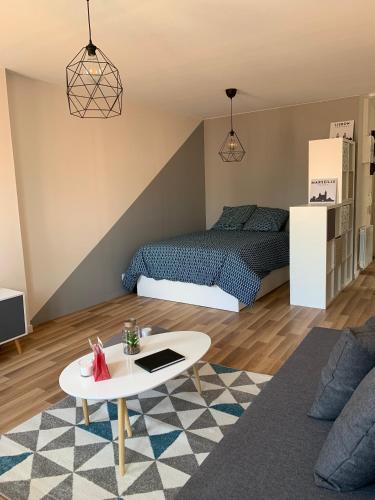 - une chambre avec un lit et une table basse dans l'établissement Esprit Studio sur plateau central, à Clermont-Ferrand