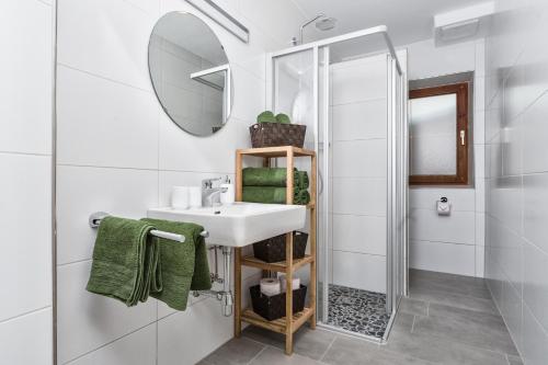 a white bathroom with a sink and a mirror at HILLSIDE Apartments Pircher in Fügen