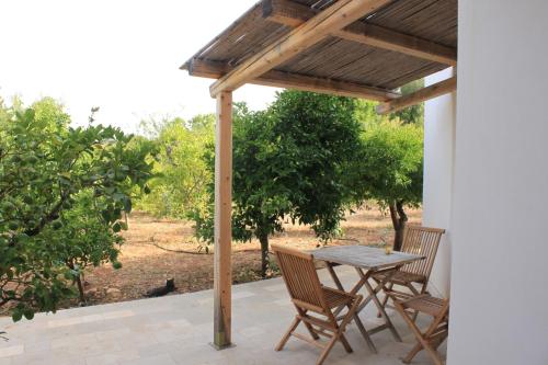 eine Terrasse mit einem Tisch und Stühlen unter einer Pergola in der Unterkunft Il Boschetto in San Vito dei Normanni
