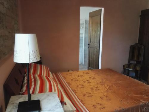 a bedroom with a bed with a lamp on a table at Da Foschetta in Matelica