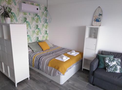 BSB Surf&Beach Apartment Salou في سالو: غرفة نوم صغيرة مع سرير وأريكة