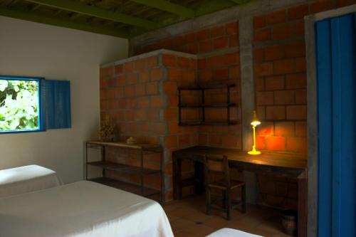 a bedroom with a bed and a table with a lamp at Soñarte Reserva Natural in Córdoba