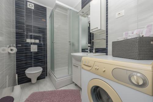 a bathroom with a washing machine and a toilet at Apartments Nataly with FREE PARKING in Makarska