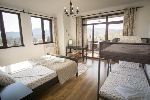 Un dormitorio con dos camas y un balcón. en Villa Pri Shtarkela, en Brodilovo