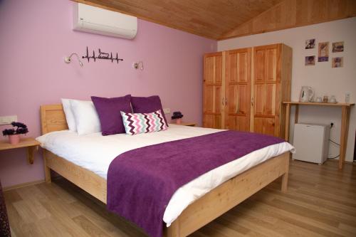 a bedroom with a large bed with purple sheets at Kara Kedi Beach Bungalow in Cıralı