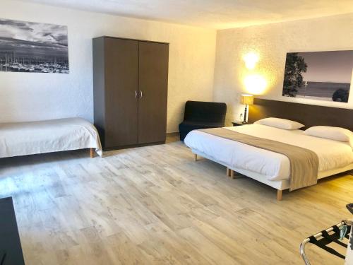 a hotel room with two beds and a chair at Hôtel Casa Rossa & Spa in LʼÎle-Rousse