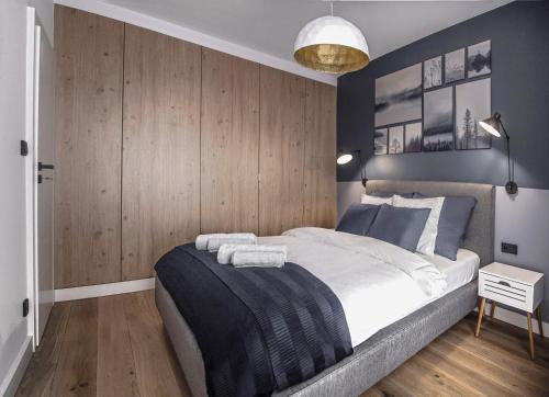 a bedroom with a large bed and wooden walls at MyCherry - Old Town Apartment - Księcia Witolda 11 in Wrocław