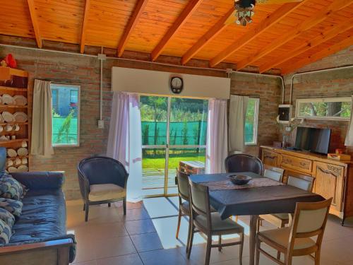 a kitchen and dining room with a table and chairs at Cabañas Bruma in Monte Hermoso