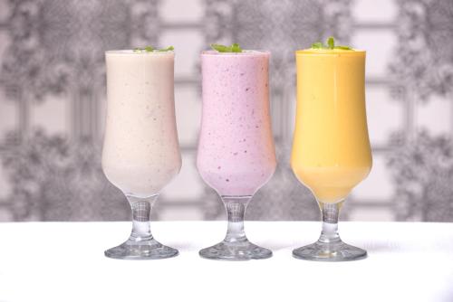 three vases filled with different colored drinks on a table at Britannia Hotel in Durban