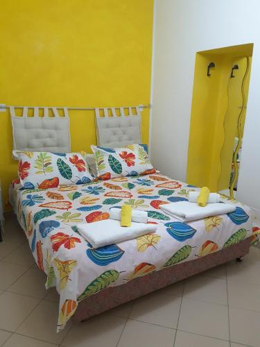 ein Schlafzimmer mit einem großen Bett und einer farbenfrohen Bettdecke in der Unterkunft B&B Odeon in Taormina