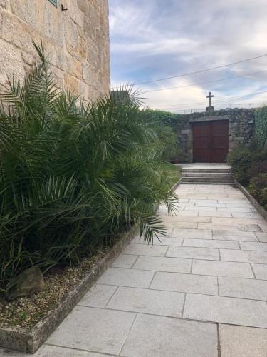 a stone walkway with plants in front of a building at Casa Rural Rectoral de Areas Tui in Tui