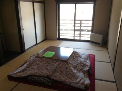 a room with a table in the middle of a room at Minshuku Ippu in Yamanouchi