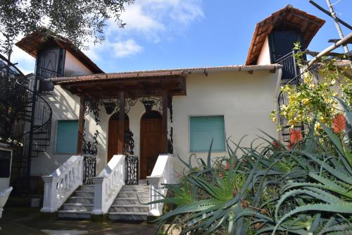 une maison blanche avec une terrasse couverte et des escaliers dans l'établissement casa dei limoni, à Massa Lubrense