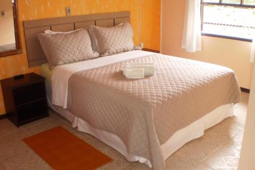 a bedroom with a large white bed with a tray on it at Pousada Estrela do Mar in Ilha do Mel