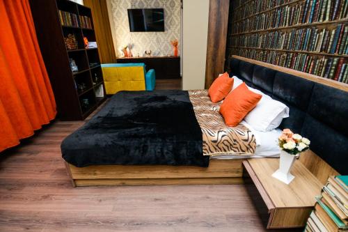 Schlafzimmer mit einem Bett mit orangefarbenen und weißen Kissen in der Unterkunft Check Inn Tbilisi in Tbilisi City