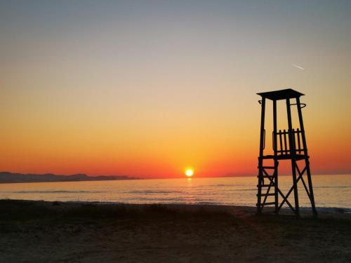 a lifeguard tower on the beach at sunset at Sirios in Acharavi