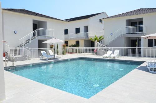 une piscine devant un immeuble dans l'établissement Residence Marea Resort, à Santa-Lucia-di-Moriani