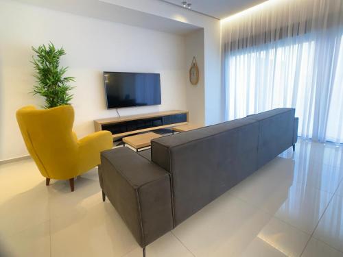a living room with a couch and a yellow chair at villalis bay view in Eilat