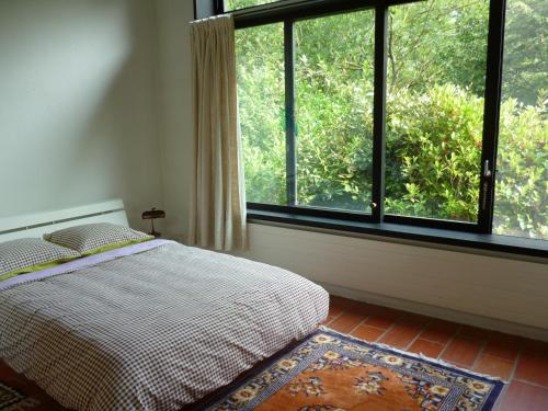 ein Schlafzimmer mit einem Bett und einem großen Fenster in der Unterkunft Casa Aline in Contra