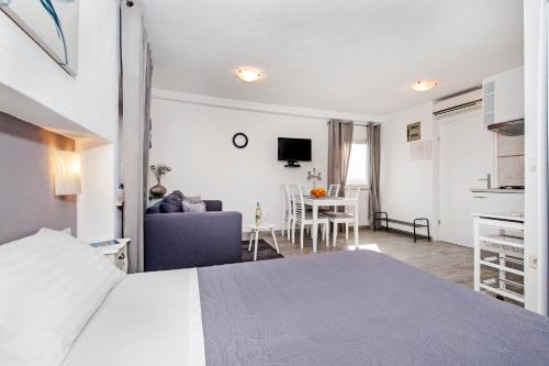 een slaapkamer met een bed en een woonkamer bij Studio Apartment Sunce in Rovinj