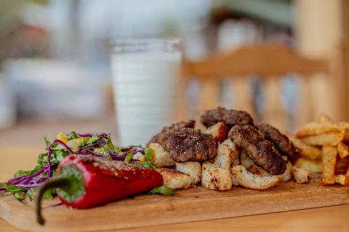 a plate of food with a strawberry and french fries at Kara Kedi Beach Bungalow in Cıralı