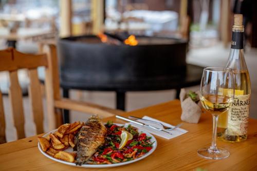 a plate of food on a table with a glass of wine at Kara Kedi Beach Bungalow in Cıralı