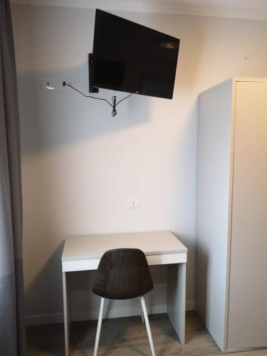 a desk with a chair and a tv on a wall at Tra I Castelli in Filiano