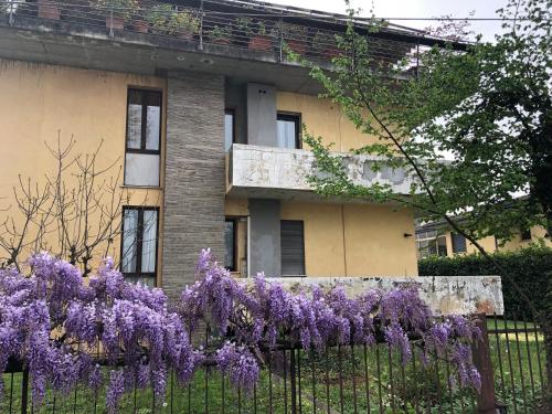 a fence with purple flowers in front of a building at Appartamento Abano Villa Bassi in Abano Terme