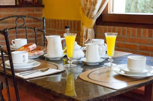 リエルガネスにあるPosada Carpe Diemの皿、オレンジジュースのグラスが入ったテーブル