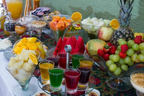 a table with a bunch of fruit and drinks at Pousada Brasil Nativo in Cabo Frio