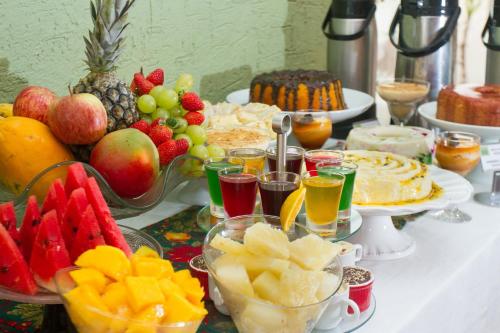 a table full of food with fruit and drinks at Pousada Brasil Nativo in Cabo Frio