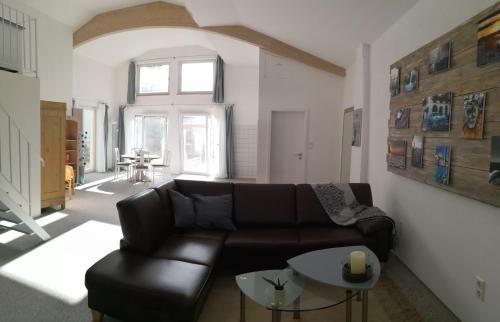 sala de estar con sofá de cuero y mesa en Sunny Loft Haus RV en Ravensburg