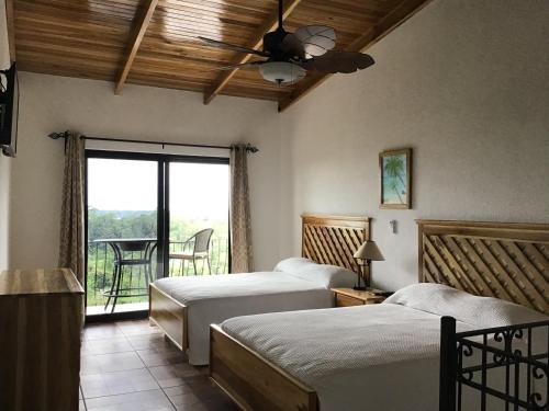 a bedroom with two beds and a ceiling fan at Hotel Los Cielos Del Caribe in Cahuita