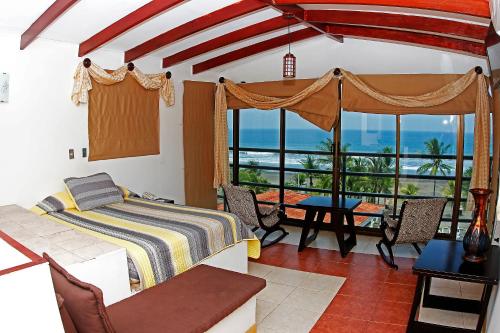 a bedroom with a bed and a view of the ocean at Balcon del Mar Beach Front Hotel in Jacó