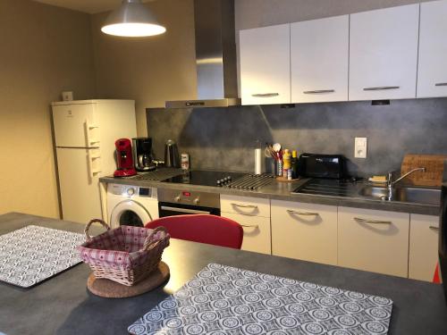 - une cuisine avec une table, un évier et une cuisinière dans l'établissement Le Paillot de Montabert Hyper Centre classé, à Troyes