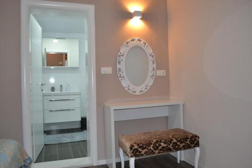 ein Badezimmer mit einem Spiegel über einem Kamin und einem Waschbecken in der Unterkunft Apartment Oaza in Mostar