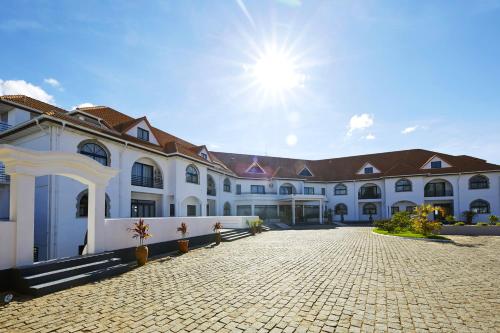 un grande edificio bianco con il sole nel cielo di San Cristobal Boutique Hotel - Ivato Airport a Antananarivo