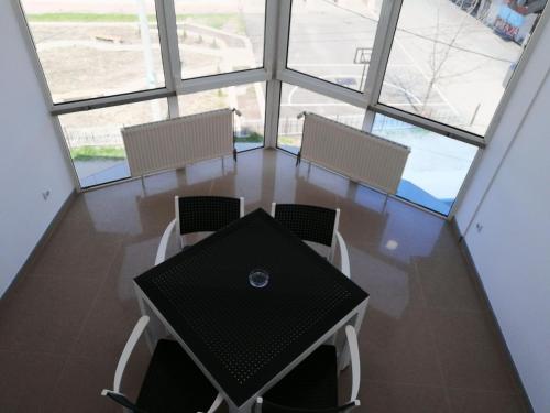 a table and chairs in a room with windows at Apartments AS Dubrave in Dubrave Gornje