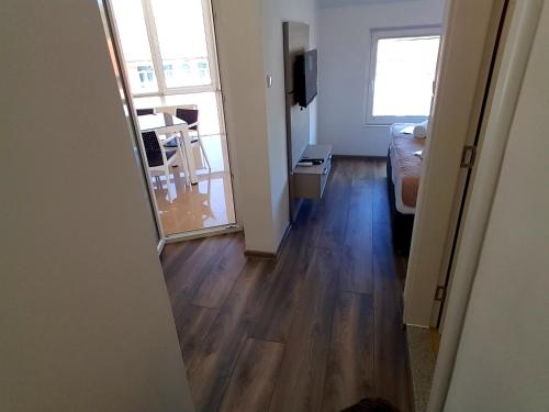 a living room with a wooden floor and a mirror at Apartments AS Dubrave in Dubrave Gornje
