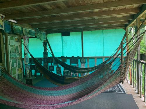 a hammock in a room with a large window at Paraisoverde-Corcovado Over Night in Drake