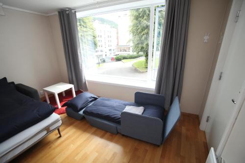 a living room with a bed and a large window at Bergen's Best Location in Bergen