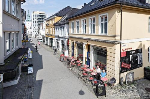 eine Straße mit einer Gruppe von Tischen und Stühlen auf einem Gebäude in der Unterkunft Bergen's Best Location in Bergen
