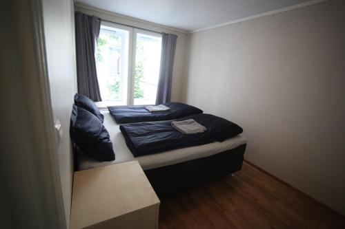 zwei Betten in einem kleinen Zimmer mit Fenster in der Unterkunft Bergen's Best Location in Bergen