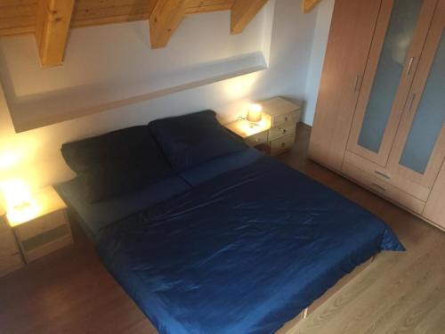 1 dormitorio con 1 cama azul y 2 lámparas en U Řeky Lužnice, en Třeboň