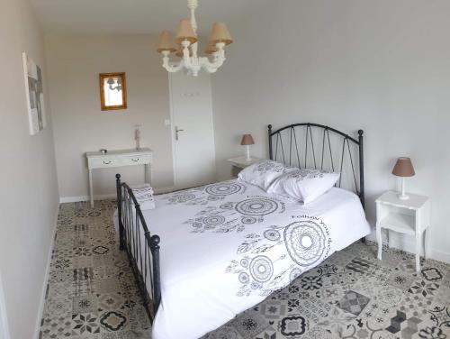 Un dormitorio con una cama en blanco y negro y una mesa en Meublé 3 étoiles, proche Plages débarquement dans les Marais du Cotentin à Carentan en Carentan