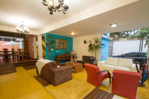 a living room with a couch and chairs at Pousada Brasil Nativo in Cabo Frio