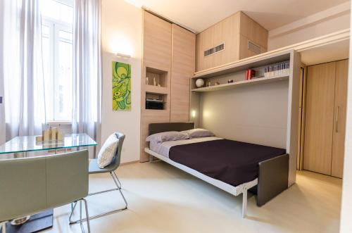 una camera con letto e tavolo in vetro di Design central studio - Porta Romana a Milano