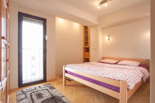 1 dormitorio con cama y ventana grande en WHITE APARTMENT, en Skopje